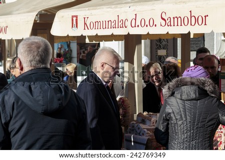 SAMOBOR, CROATIA - JANUARY 04, 2015: Ivo Josipovic the third President of Croatia on the promotion for the next presidential election in Croatia. The President looking at stand with homemade products.