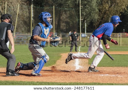 ZAGREB, CROATIA - OCTOBER 12, 2014: Baseball match Baseball Club Zagreb in blue jersey and Baseball Club Olimpija in dark blue jersey. Unidentified baseball runner, catcher and plate umpire