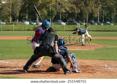 ZAGREB, CROATIA - OCTOBER 12, 2014: Baseball match Baseball Club Zagreb in blue jersey and Baseball Club Olimpija in dark blue jersey. Unidentified baseball batter, catcher and plate umpire