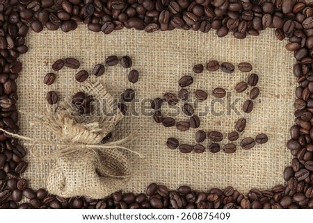 Arabica coffee beans in shape of a hart and coffee mug on burlap background in coffee beans frame