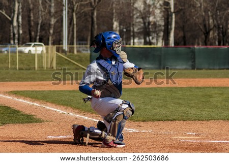 ZAGREB, CROATIA - MARCH 21, 2015: Baseball match Baseball Club Zagreb in blue jersey and Baseball Club Olimpija in gray jersey. Baseball catcher is throwing the ball