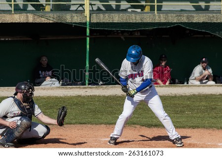 ZAGREB, CROATIA - MARCH 21, 2015: Baseball match Baseball Club Zagreb in blue jersey and Baseball Club Olimpija in gray jersey. Unidentified baseball batter leaning forward as he miss the shot