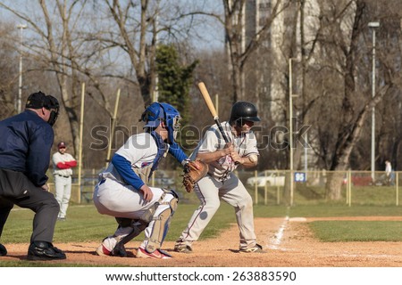 ZAGREB, CROATIA - MARCH 21, 2015: Baseball match Baseball Club Zagreb in blue jersey and Baseball Club Olimpija in gray jersey. Baseball batter, catcher and plate umpire