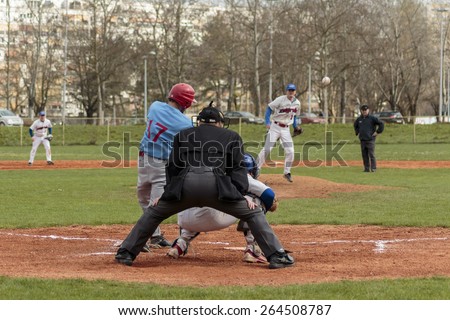 ZAGREB, CROATIA - MARCH 28, 2015: Baseball match Baseball Club Zagreb in white jersey and Baseball Club Nada in blue jersey. Baseball batter, catcher and plate umpire. View from back