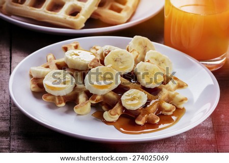 Waffles with bananas covered with maple syrup, processed with vintage filter