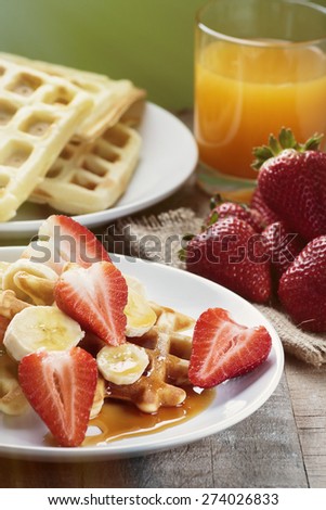 Waffles with bananas and strawberries covered with maple syrup, processed with vintage filter