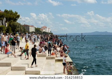 ZADAR, CROATIA - AUGUST 17, 2015: People relaxing and swimming at Zadar famoust Sea Organs. The sea organ won European Prize for Urban Public Space award in 2006.