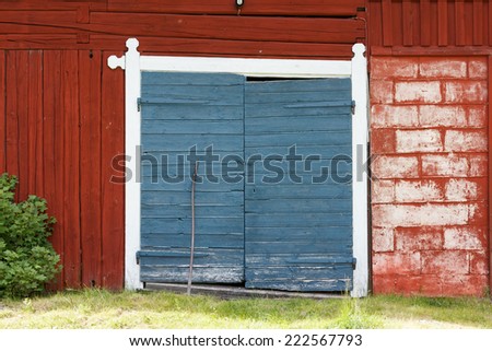 Red painted barn with two blue painted doors