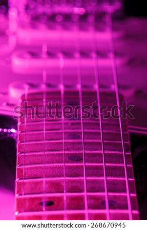 A six string electric guitar with purple light in a vertical composition