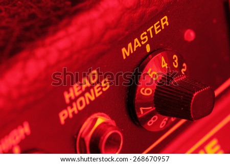 Master volume knob of a guitar amplifier in red light