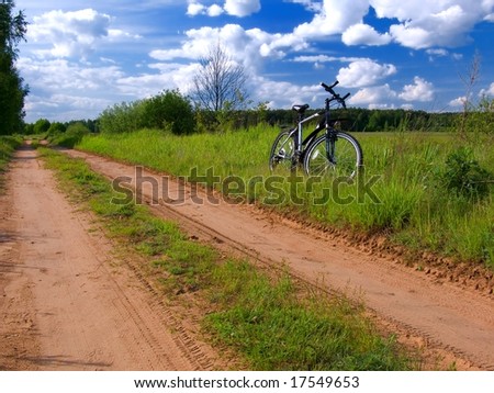 Bicycle by side of road through countryside in summer scene