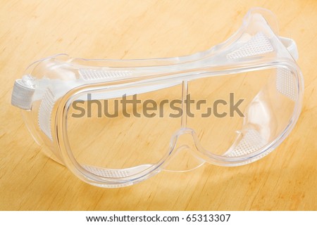 Industrial safety glasses - over a wooden background