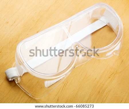 Industrial safety glasses - over a wooden background