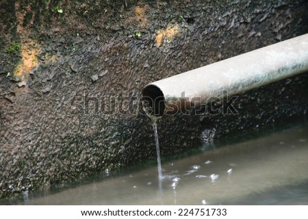 The old drain pipe with water against the pit