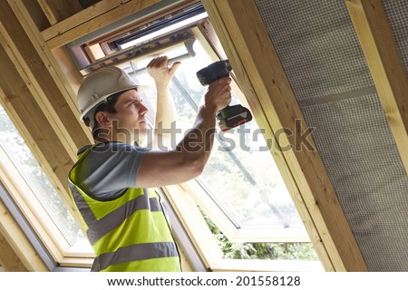 Construction Worker Using Drill To Install Window