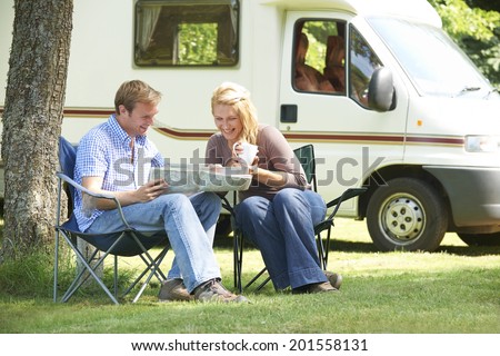 Couple Relaxing Outside Motor Home On Vacation