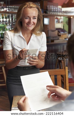 Waitress In Restaurant Taking Order From Customer