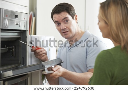 Engineer Giving Woman Advice On Kitchen Repair