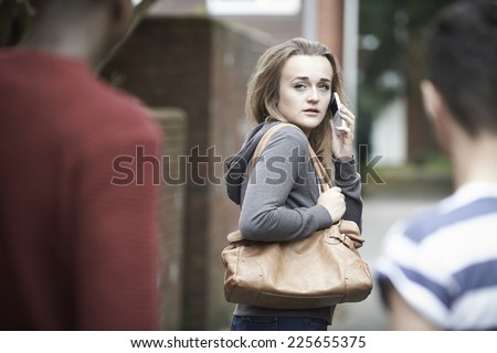 Teenage Girl Using Phone As She Feels Intimidated On Walk Home