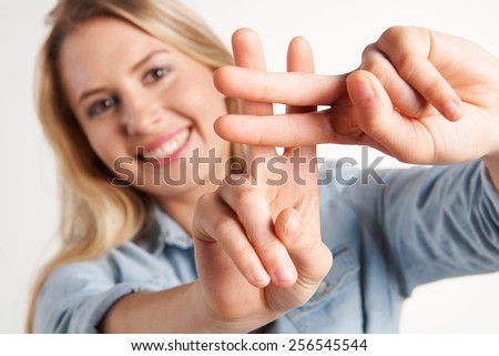 Pretty Girl Making Hash Tag Sign With Fingers - stock-photo-pretty-girl-making-hash-tag-sign-with-fingers-256545544