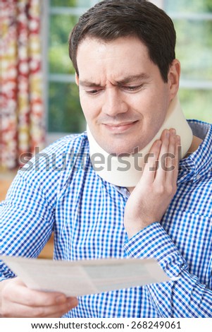 Man Reading Letter After Receiving Neck Injury