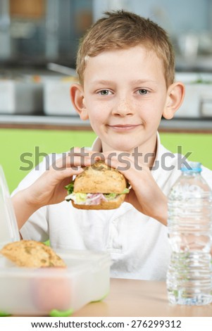 Pupil Sitting In School Cafeteria Eating Healthy Packed Lunch