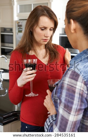 Sad Woman Being Consoled At Home By Female Friend
