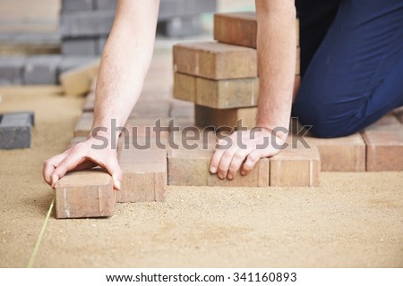 Man Laying Blocks For Patio