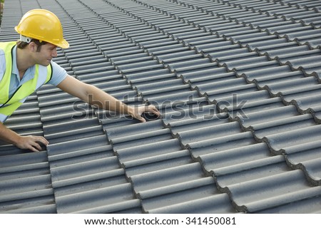 Builder Working On Roof Of New Building