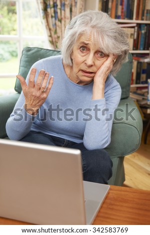 Frustrated Senior Woman Trying To Use Laptop Computer