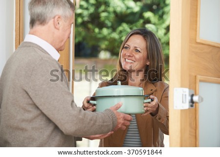 Woman Bringing Meal For Elderly Neighbor