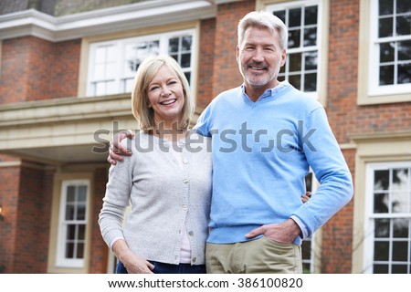 Portrait Of Mature Couple Standing Outside Home