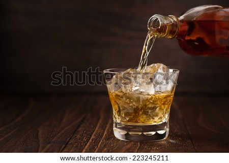 Pouring Scotch drink into glass