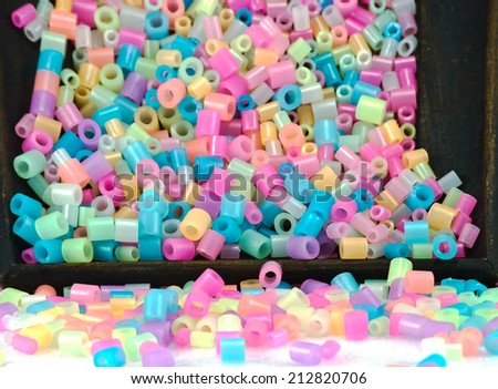 close Up of pixel beads, plastic granules or plastic beads on small clippers