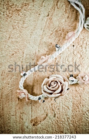vintage of artificial flowers rose on the old paper stripes.