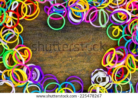 colorful Rainbow loom bracelet rubber bands fashion on old wood background.