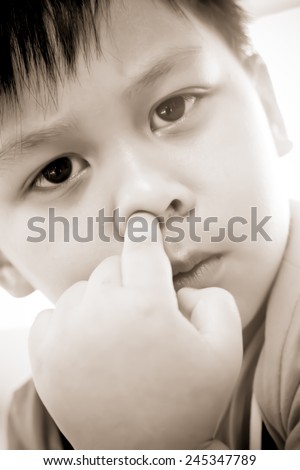 Young boy picking his nose
