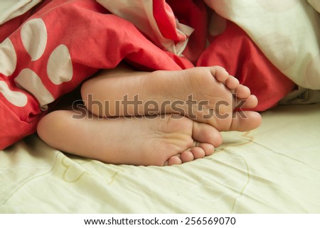 close up child feet in bed