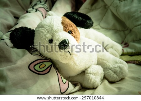Vintage of doll dog alone on bed