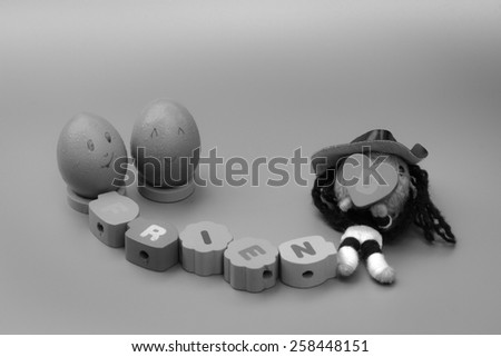 friendship concept : two eggs with friend letters on color wood in black and white color