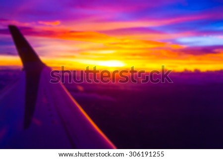 Blurry of Twilight and sunset over the clouds and the wing of the plane.