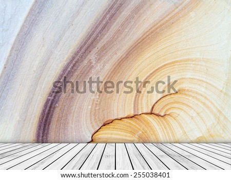 Backdrop sandstone wall and wood slabs arranged in perspective texture background.