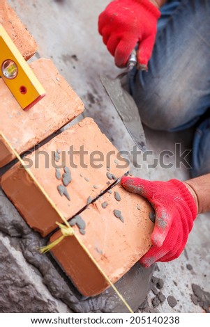 Bricklayer with brick at a construction site