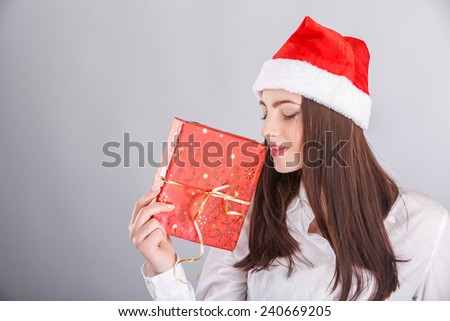 Christmas Santa hat. woman portrait hold christmas gift. Smiling happy girl.christmas, x-mas, winter, happiness concept - smiling woman in sweater and hat with gift box