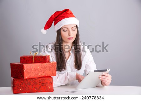 christmas, technology, shopping and people concept - smiling woman in santa helper hat with tablet pc computer and credit card.  brunette shopping online with tablet