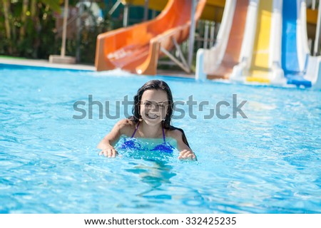Happy  girl in bikini sliding water park.