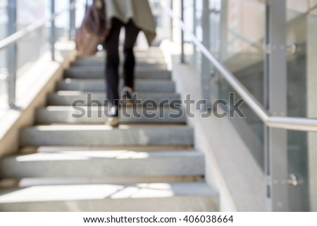 blur stairs background. women\'s legs go up the stairs