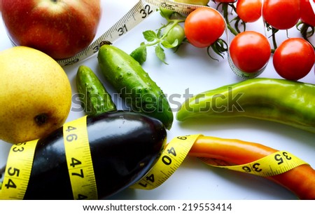 vegetables and fruits for weight loss, a measuring tape, diet, weight loss,cherry tomatoes, green peppers.cucumber.eggplant