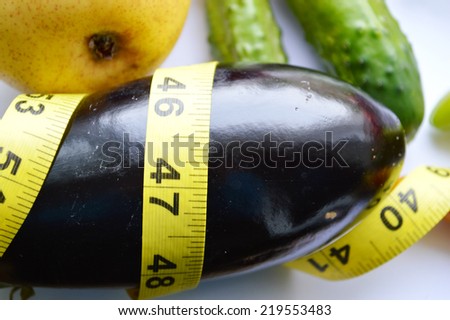 vegetables and fruits for weight loss, a measuring tape, diet, weight loss,cherry tomatoes, green peppers,eggplant,pear.cucumber