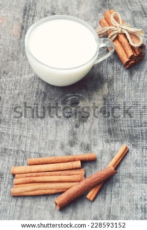 cup of hot milk with cinnamon, closeup , wooden background